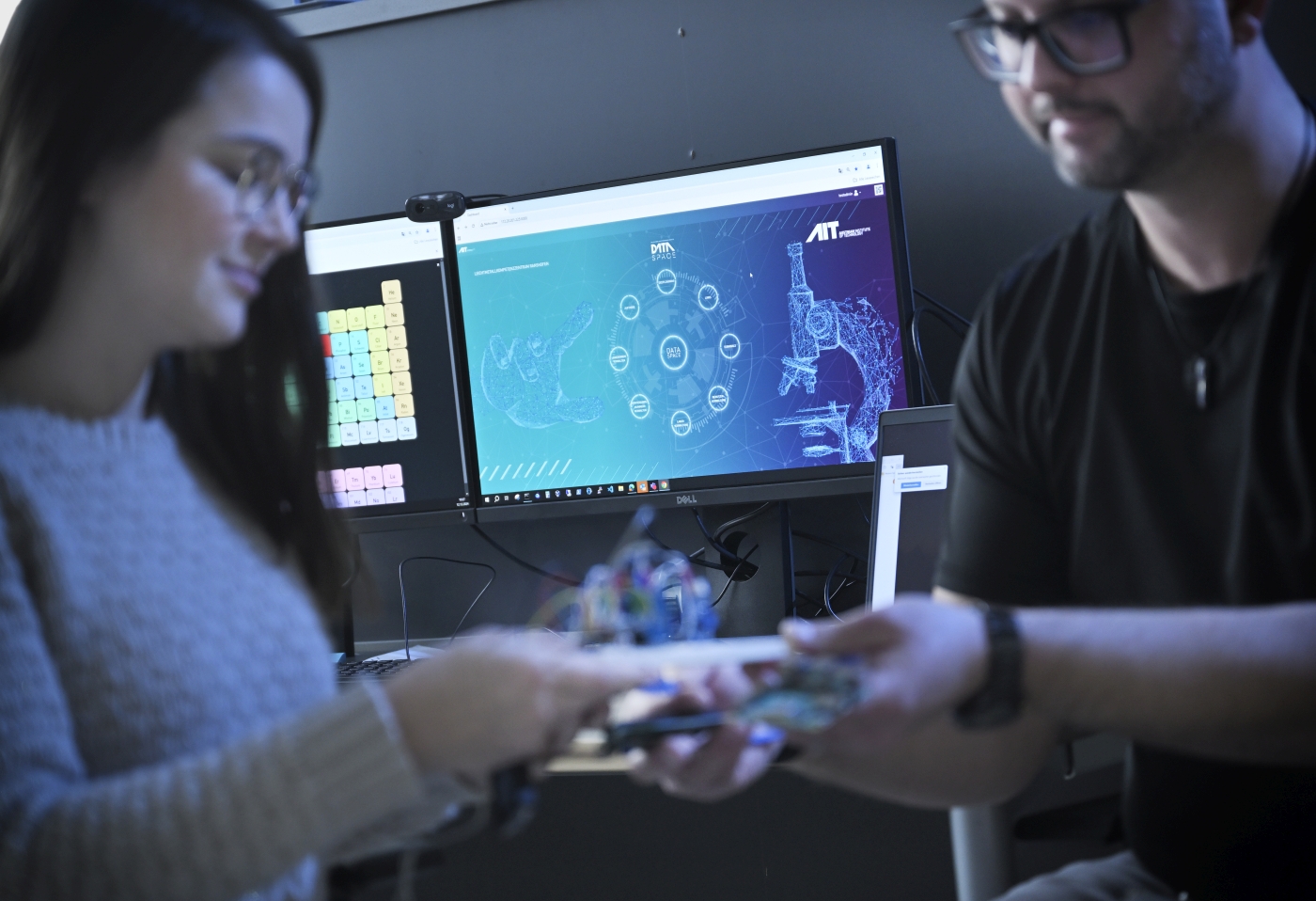Two researchers in front of a screen