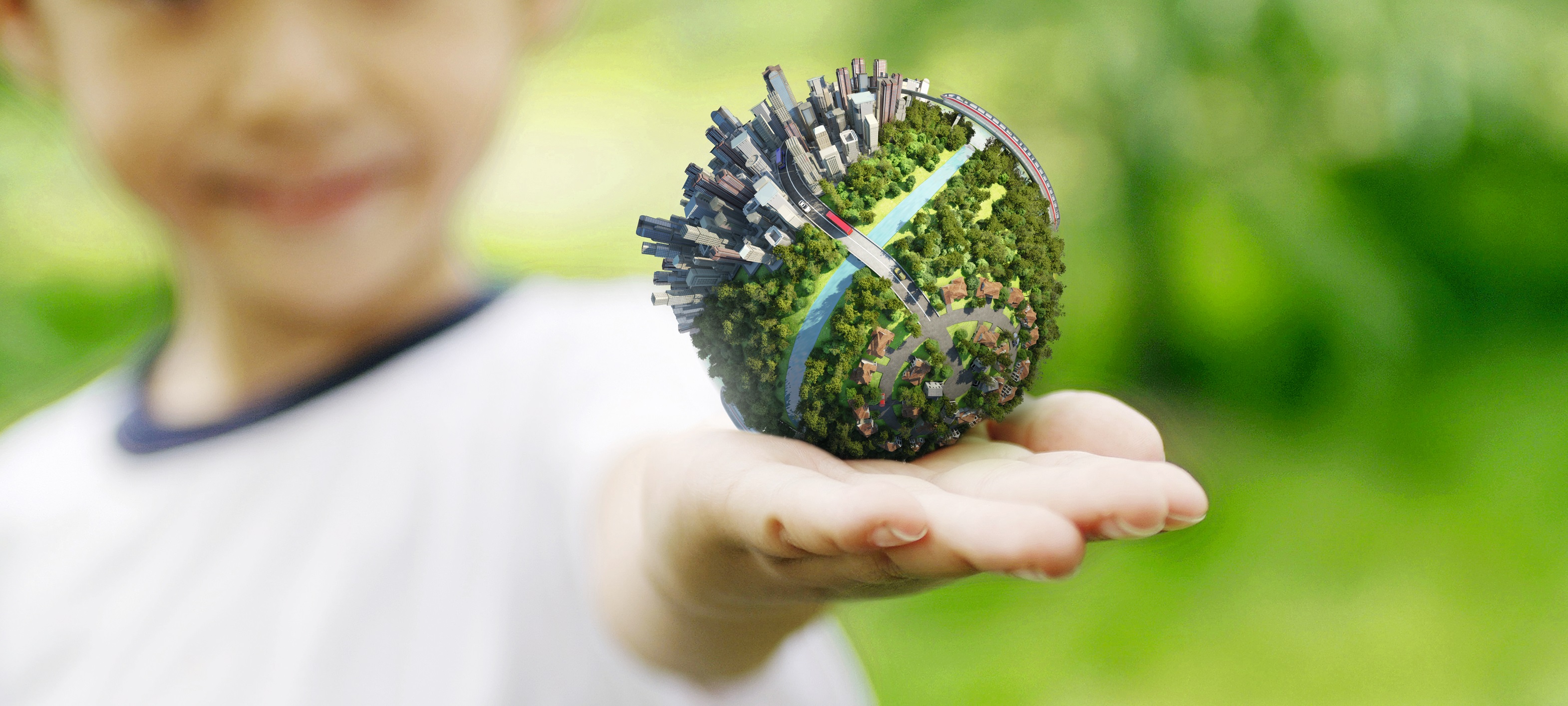 [Translate to English:] child holds a small inhabited earth in his hand