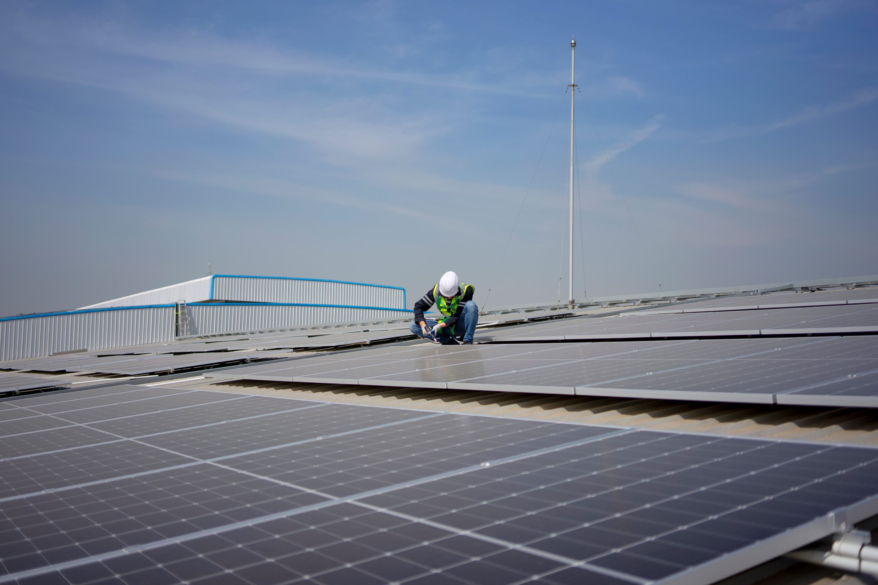 Person auf Dach montiert/demontiert Solarpanele