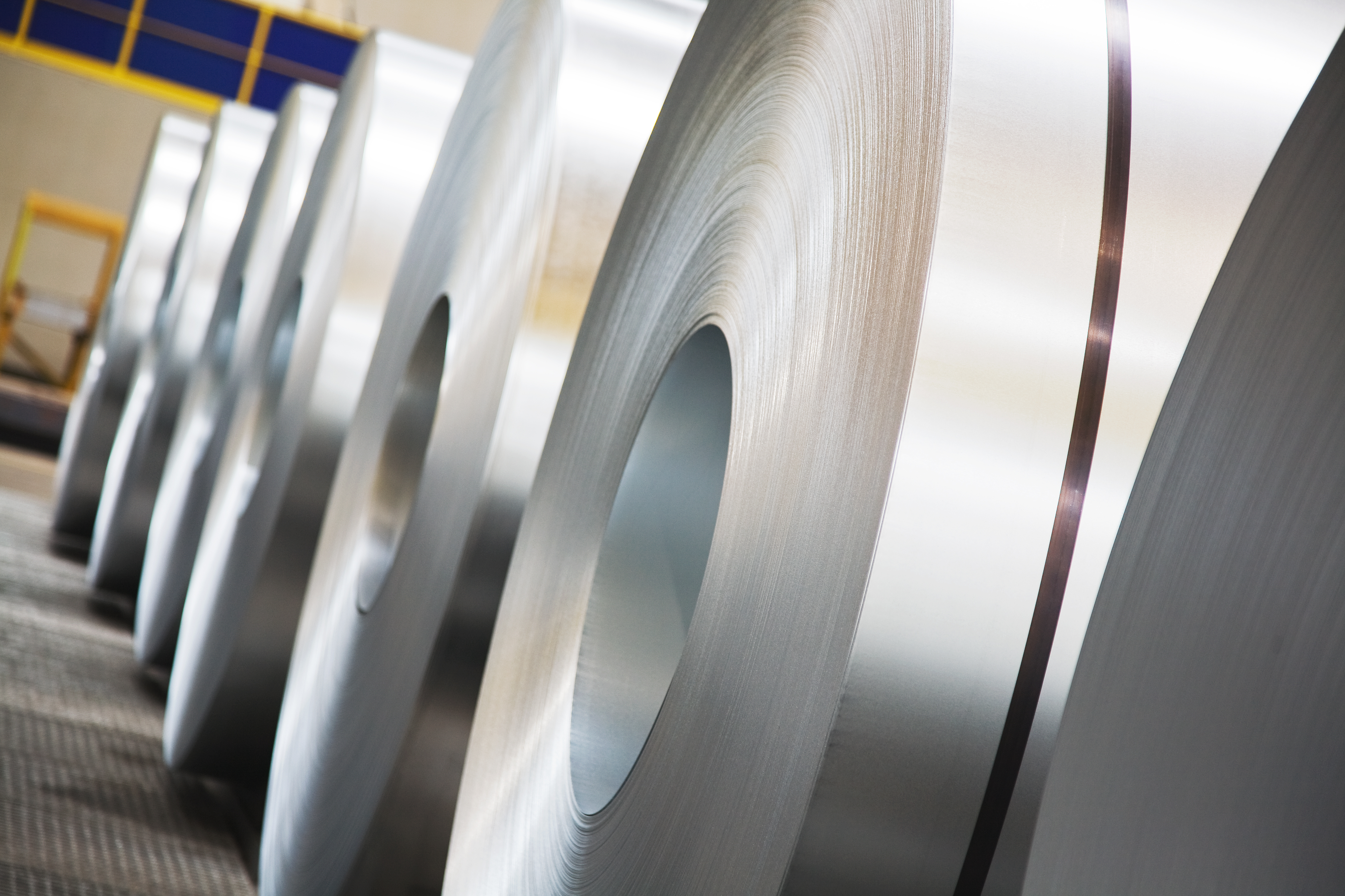 Seitlicher Blick auf aufgerollte, graue  Stahlbänder  in der Industrieanlage der voest
